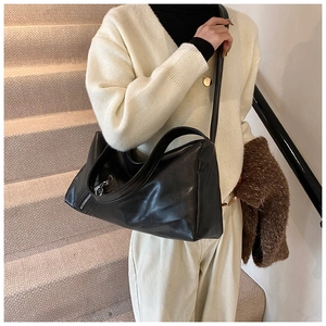 Detail of high-quality black faux leather tote with silver zipper and wide shoulder strap