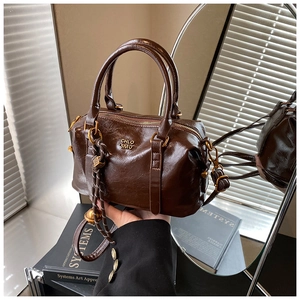 Detail of dark brown glossy leather bowling bag with vintage gold hardware and lettering