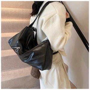 Detail of the high-quality black faux leather texture and metallic ring zipper on the tote bag