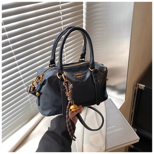 Detail of vintage black bowling bag with wrinkled texture and golden hardware