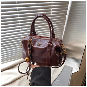 Detailed view of deep brown vintage bowling bag with gold hardware and tassel accents