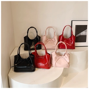 Detailed display of glossy leather tote bags with bows in black pink and red