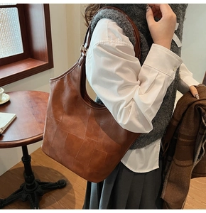 Detailopname van retro bruine lederen patchwork shopper met metalen verstelbare gesp