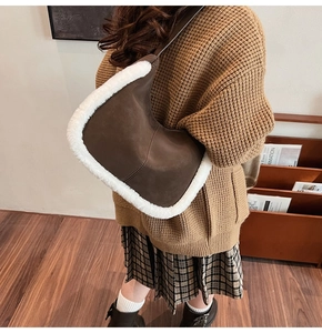 Detail of brown suede tote bag with white plush fleece trim shown from a side view