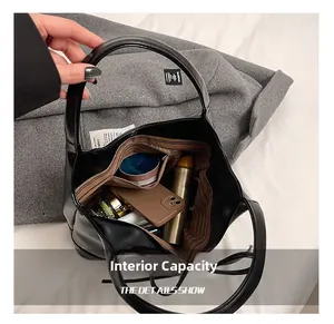 Top view of spacious black leather tote interior with striped lining and zipper pocket