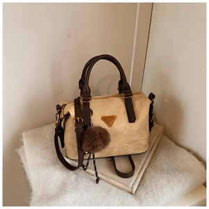 Detail showing the vintage Boston handbag with metal triangle logo and plush pendant