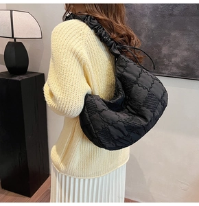 Close-up of black quilted nylon moon bag with chic pleated scrunchie shoulder strap