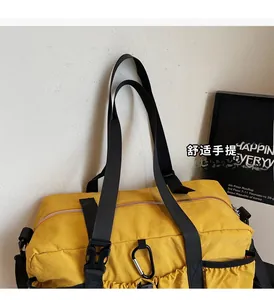 Detail of yellow nylon bucket bag showing reinforced handles, buckle, and side pocket