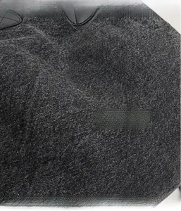Detailed macro shot of grey denim fabric texture with black stitched leather accent