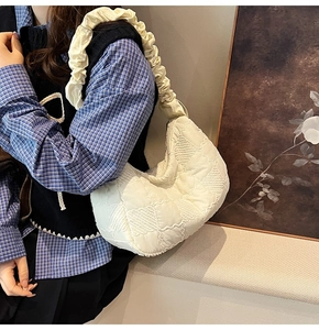 Side view of cream pleated nylon tote bag featuring ruffled shoulder strap details