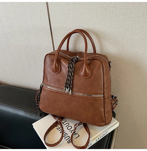 Dettaglio zaino vintage in pelle PU marrone con nappe intrecciate e doppi manici