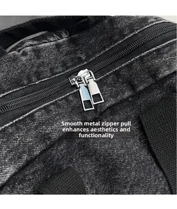 Detail view of the smooth silver metal dual zippers on black washed denim backpack
