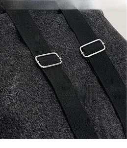 Detail of durable grey denim backpack fabric with silver metal buckles and straps