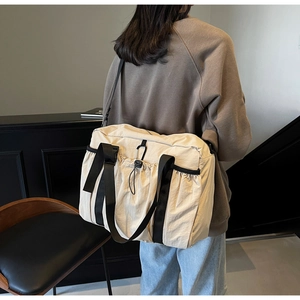 Detailed back view of a beige nylon tote bag showing durable black shoulder straps