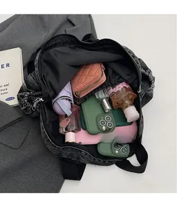Spacious interior of black washed denim backpack with umbrella and daily essentials