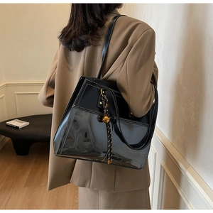 Detailed back view of a large black patchwork tote bag with white stitching and tassel