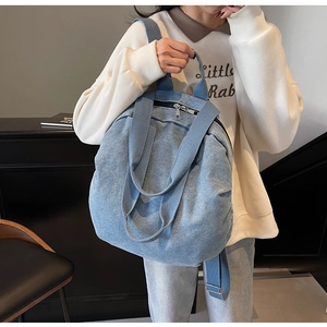 Detail of adjustable denim backpack straps with sturdy metal buckles and woven top handle