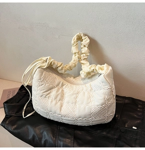 Detail of off-white quilted nylon tote bag with scrunchie handle and drawstring design