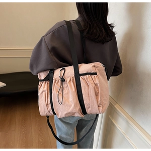 Detail view of the pink pleated nylon tote bag featuring a black strap and carabiner clip