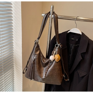 Detailed close-up of dark brown vintage tote bag with a baseball glove charm on hanger