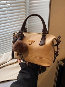 Chic beige and brown leather Boston bag with gold triangle logo and fur pom-pom detail