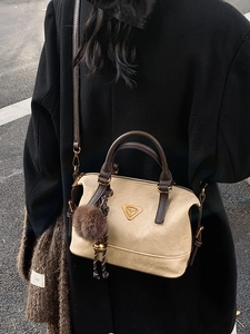 Chic beige and brown crossbody pillow bag with metal logo and faux fur charm
