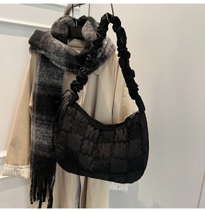 Detail of black quilted nylon crescent tote with scrunchie shoulder strap design