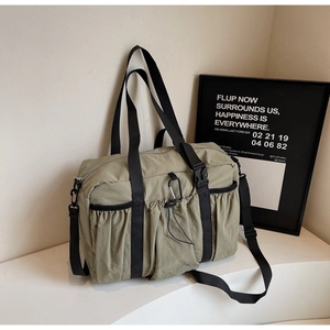 Close-up of khaki nylon tote bag with drawstring pocket and silver metal carabiner