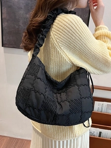 Fashionable black quilted nylon tote bag with pleated shoulder straps worn by a model