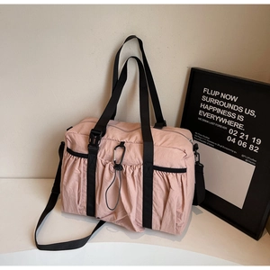 Detail of light pink waterproof nylon bucket bag with pleats and black webbing straps