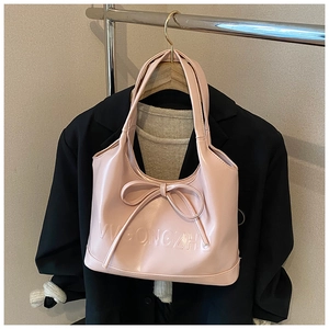 Detail of pink PU leather tote bag with decorative bow and VVGONGZHU embossed lettering