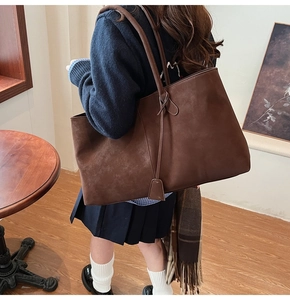 Brown suede tote bag with large capacity and decorative leather tags for daily use