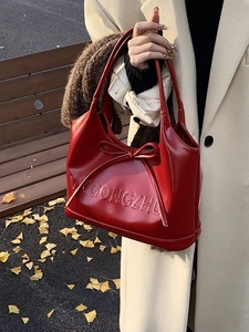 Elegant red leather handbag with bow detail and shoulder strap for autumn fashion