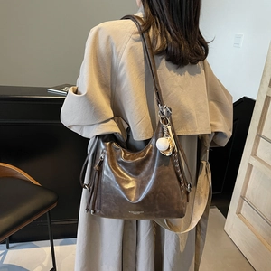 Retro brown leather tote bag with moon shape and adjustable strap shown on model