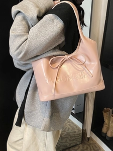 Pink glossy faux leather tote bag with bow detail and shoulder strap for women