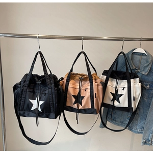 Tre grandi borse tote in nylon con motivi a stella appese in nero e kaki