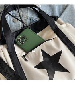 Dettaglio della borsa tote in nylon bianco con stampa a stella nera e tasca laterale