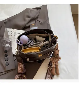 Detalle del bolso cubo marrón retro mostrando el amplio espacio interior y los compartimentos
