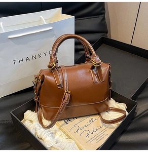 Detailed shot of brown leather boston bag in elegant gift box with premium packaging