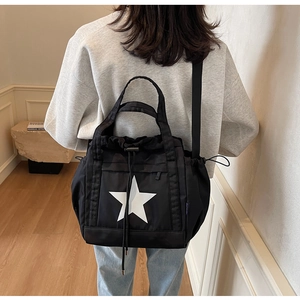 Dettaglio della borsa tote in nylon nero con stella bianca e coulisse sulla spalla