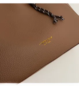 Macro shot of dark brown litchi pattern leather with golden stamped fashion logo