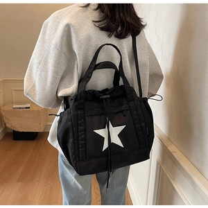 Dettaglio della borsa tote in tela nera con stampa a stella e design con coulisse