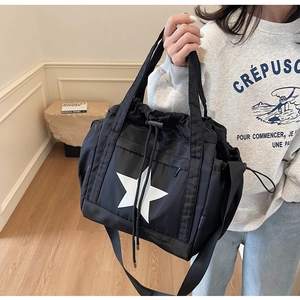 Dettaglio della borsa nera con coulisse con grande stella bianca e tracolla in nylon