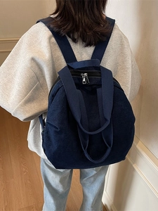 Large capacity navy denim backpack with top handle for women, shown in casual daily usage
