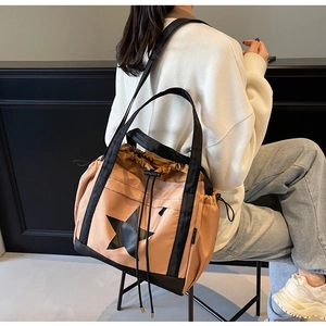Dettaglio della borsa tote rosa con coulisse, grande stella nera e doppie tracolle