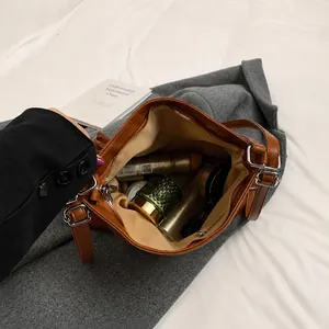 Vista interior del bolso tote de cuero marrón con gran capacidad y cierre de cremallera