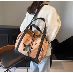 Dettaglio della borsa tote in nylon con stella, chiusura a coulisse e doppi manici