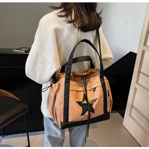 Dettaglio della borsa tote rosa e nera con stampa a stella e chiusura a coulisse