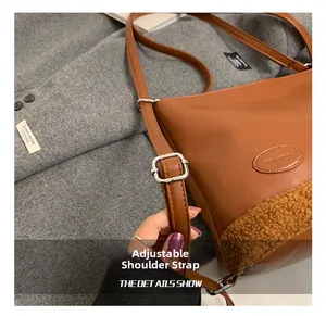 Detalle de la correa de cuero ajustable con hebilla plateada en el bolso marrón