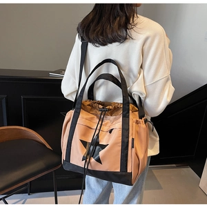 Borsa tote rosa e nera con stella indossata da modella mostra capienza e coulisse detail